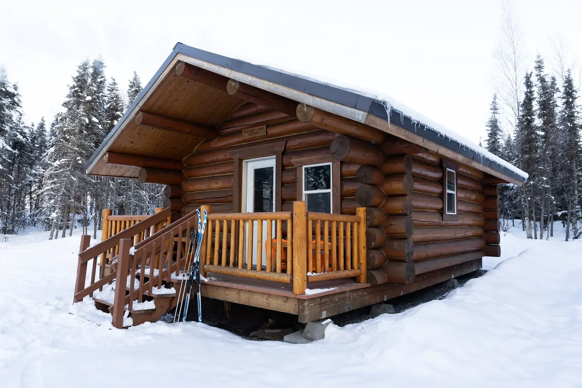Log cabin in deep snow, a winter vacation rental that needs seasonal checks from Airbnb management in Bend, Oregon
